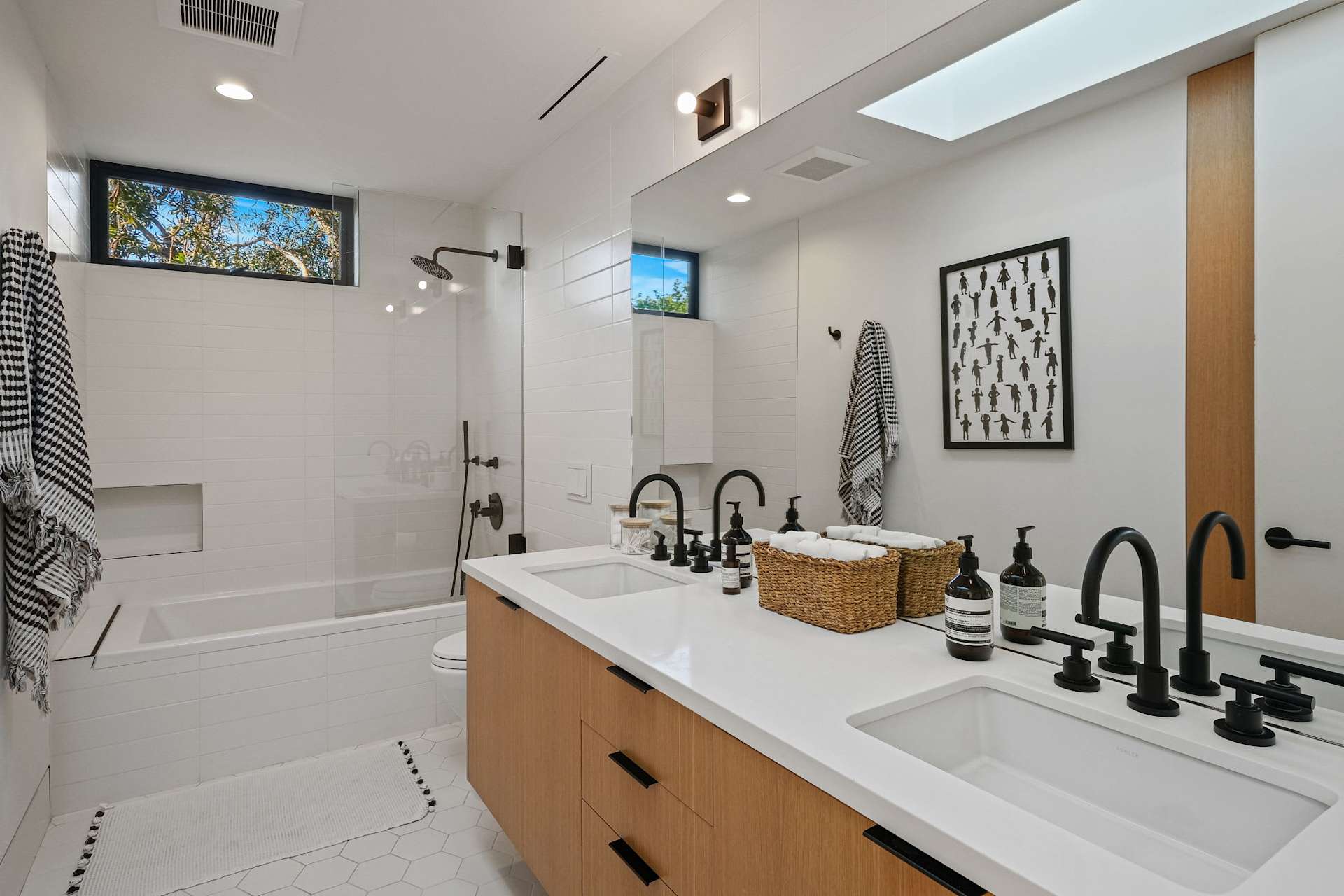 Modern bathroom with double vanity and glass shower enclosure.