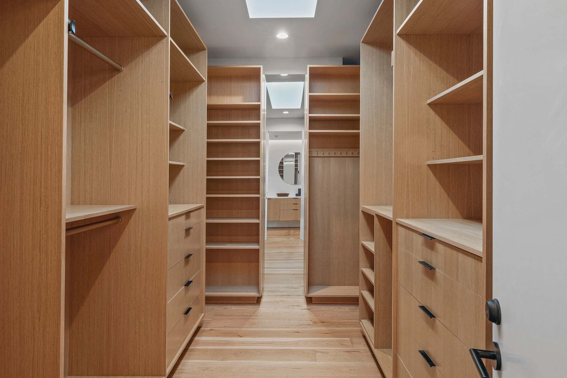Custom walk-in closet with built-in wood shelving and drawers.
