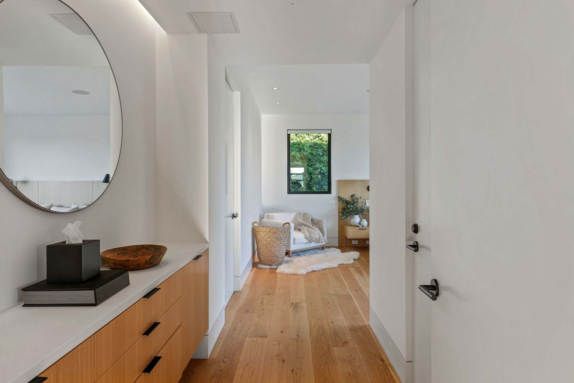 Modern bedroom hallway with custom storage and wood flooring.