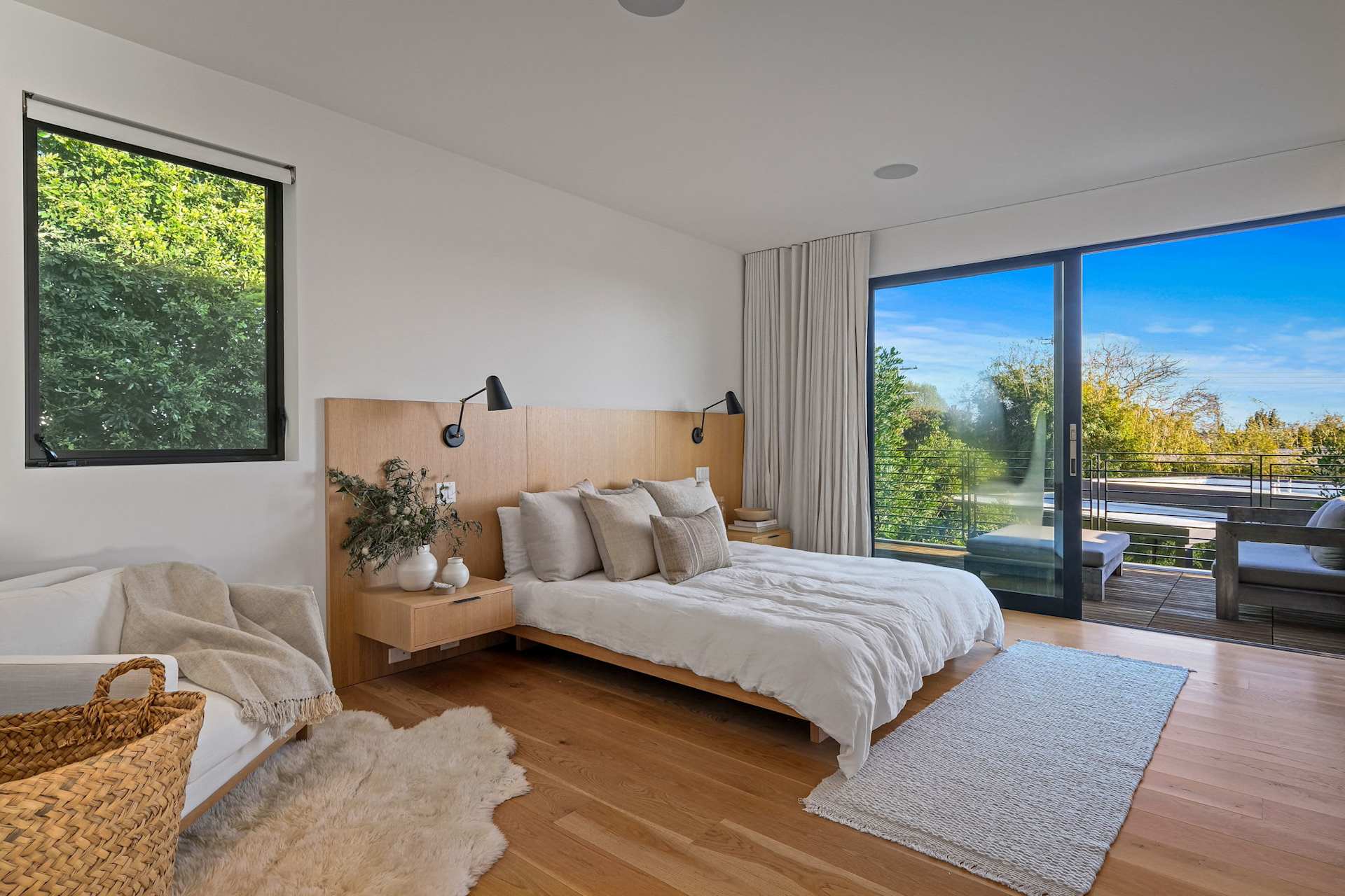 Primary bedroom with balcony access and modern wood finishes.