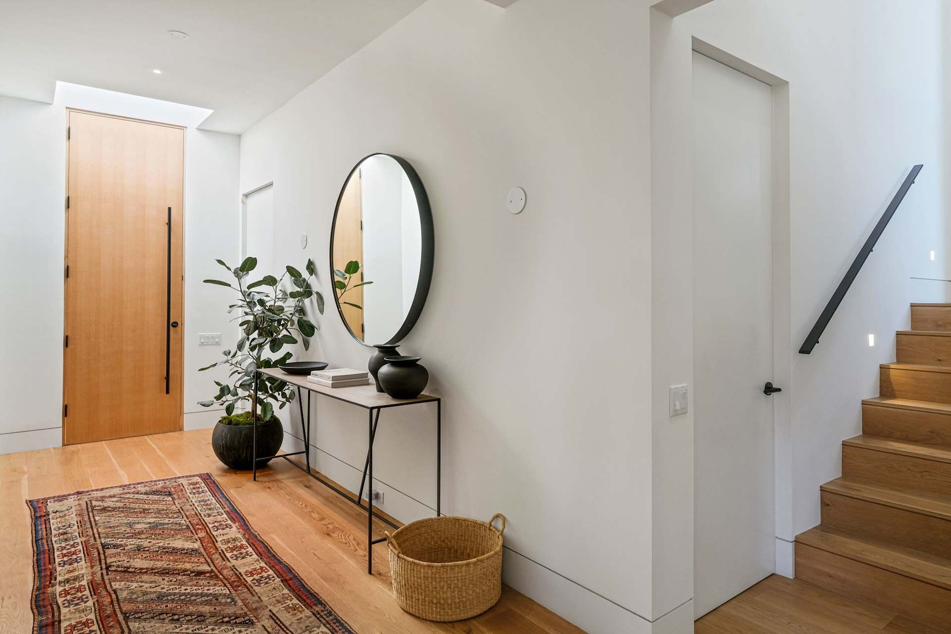 Modern entryway with a wood front door and a custom console table.