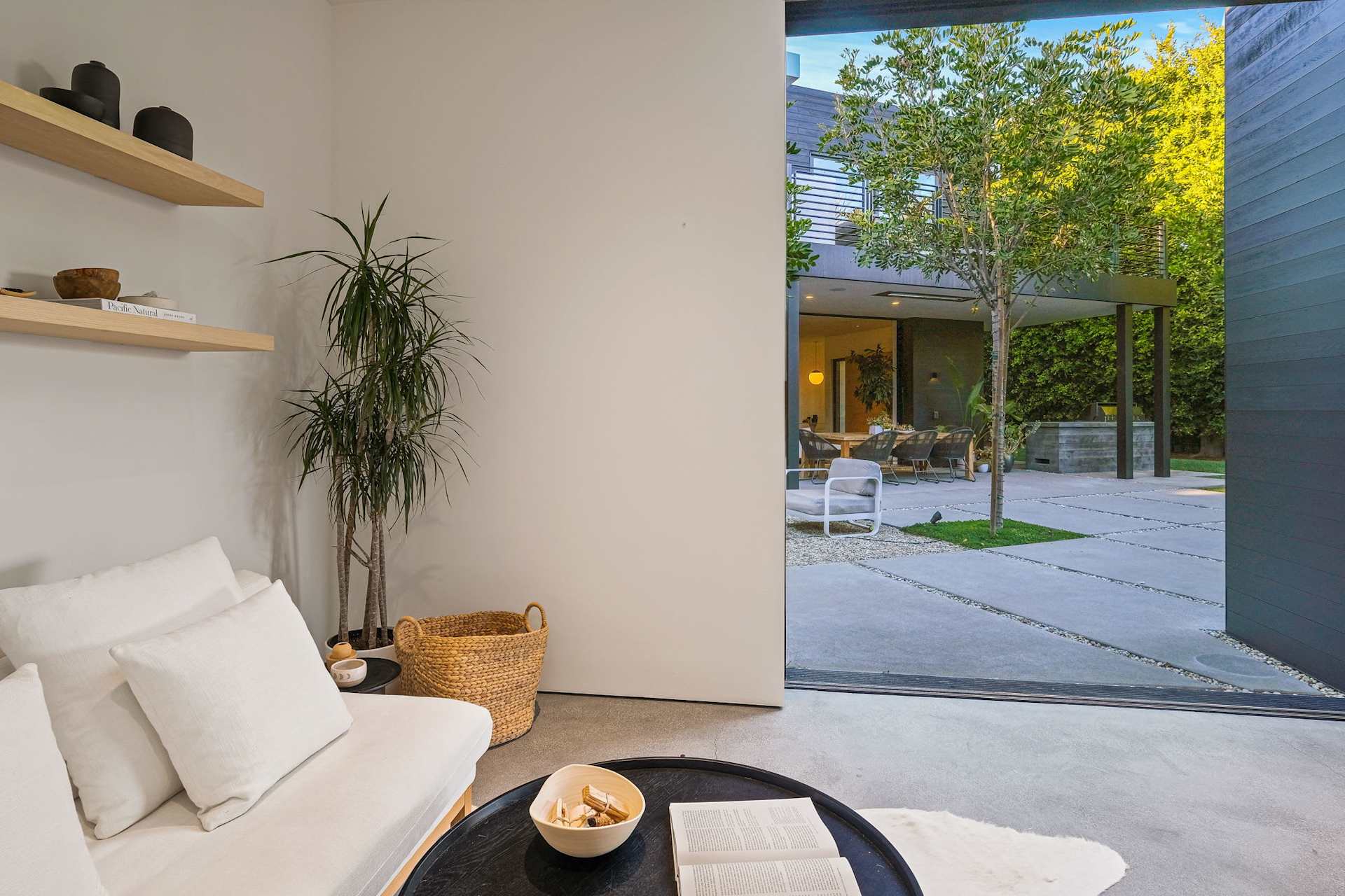 Detached ADU lounge with modern seating, floating shelves, and polished concrete floors.