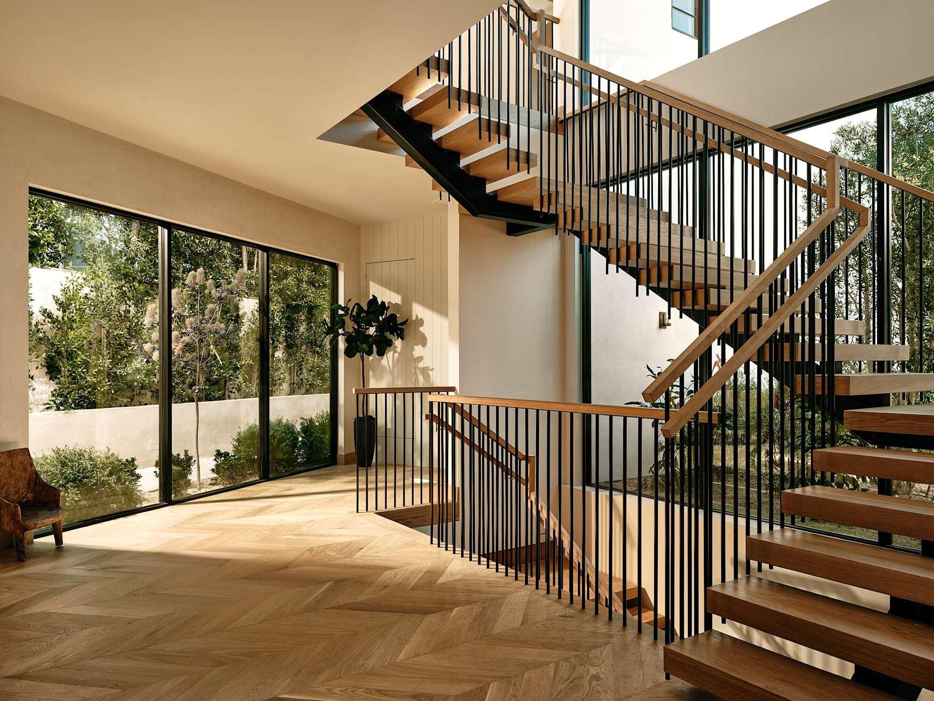 Modern staircase entryway with wood steps and floor-to-ceiling windows