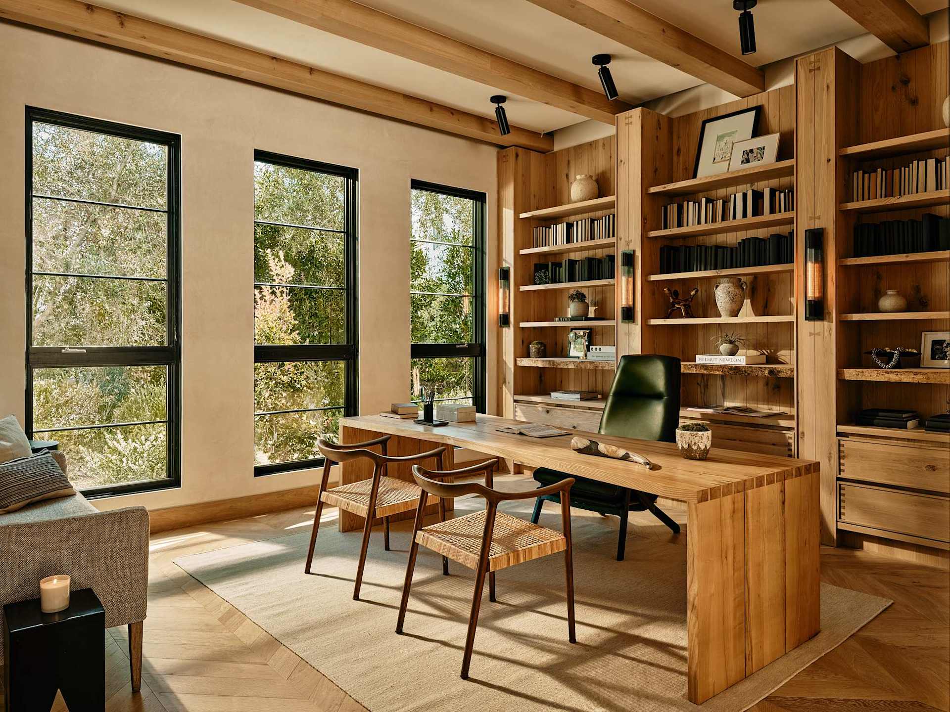 Custom home office with built-in shelving, wood desk, and large windows