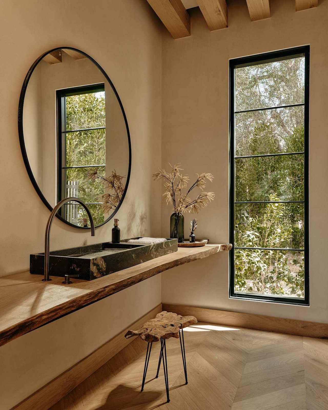 Powder room with stone vessel sink, live-edge vanity, and round mirror