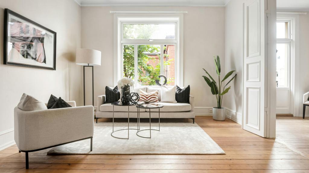 Room addition planning inspiration showing a renovated living room with expanded space, large windows, modern furniture, and improved home functionality
