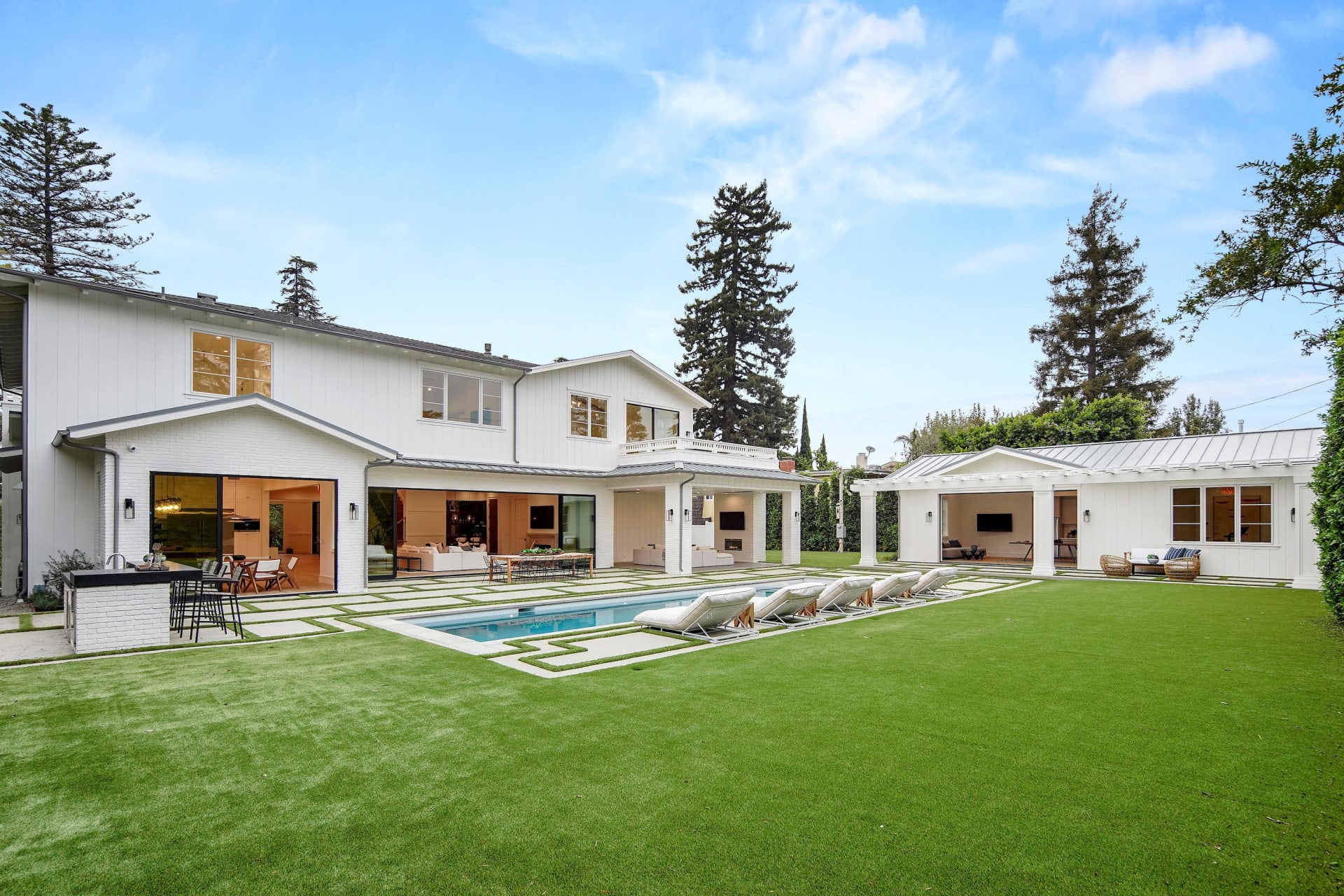 Rear exterior of the South Bundy home with a swimming pool, lawn and covered patio