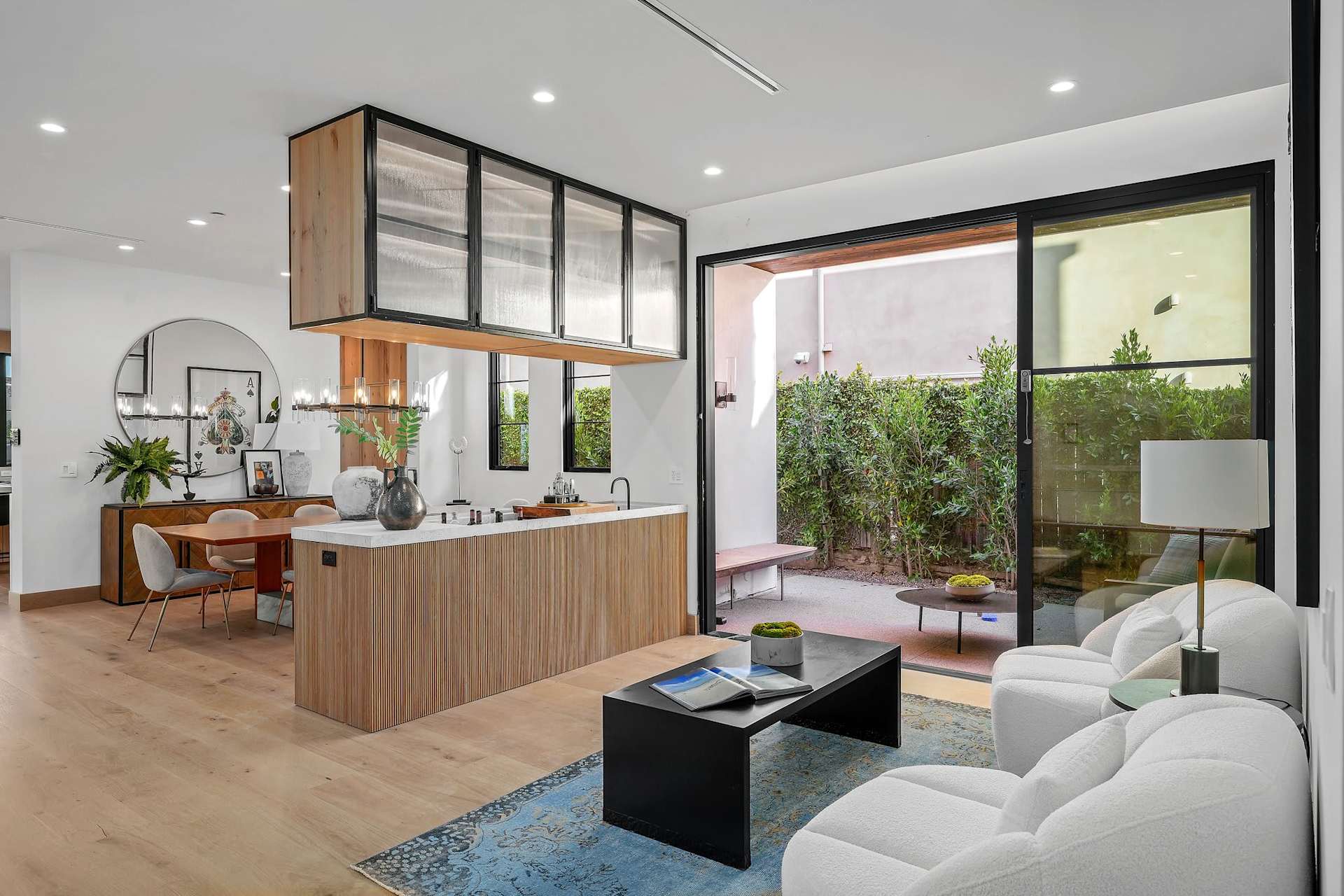 Stylish lounge area with built-in wet bar, sliding glass doors, modern seating, and indoor outdoor flow