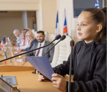 Girl giving speech present on stage with microphone