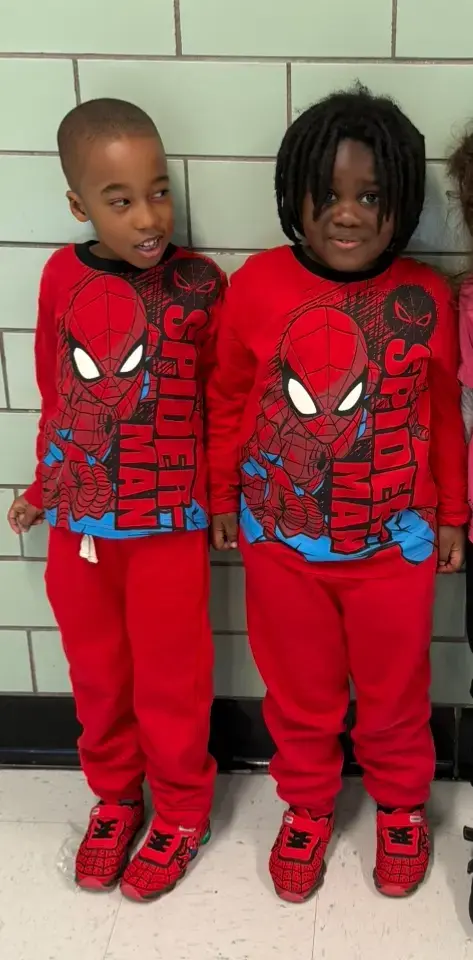 Two students wearing matching red Spider-Man outfits