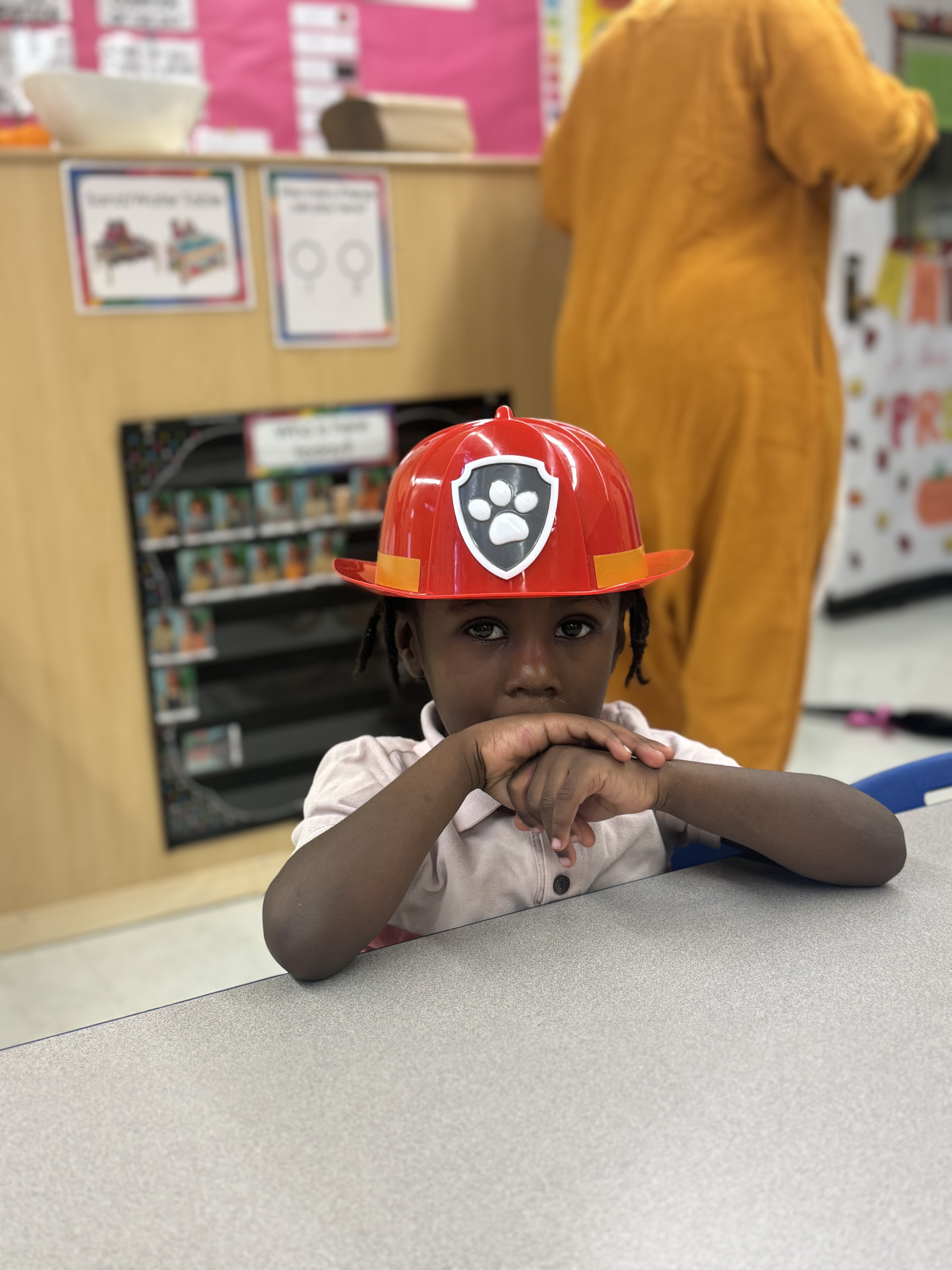 Student wearing a red Paw Patrol costume hat in classroom