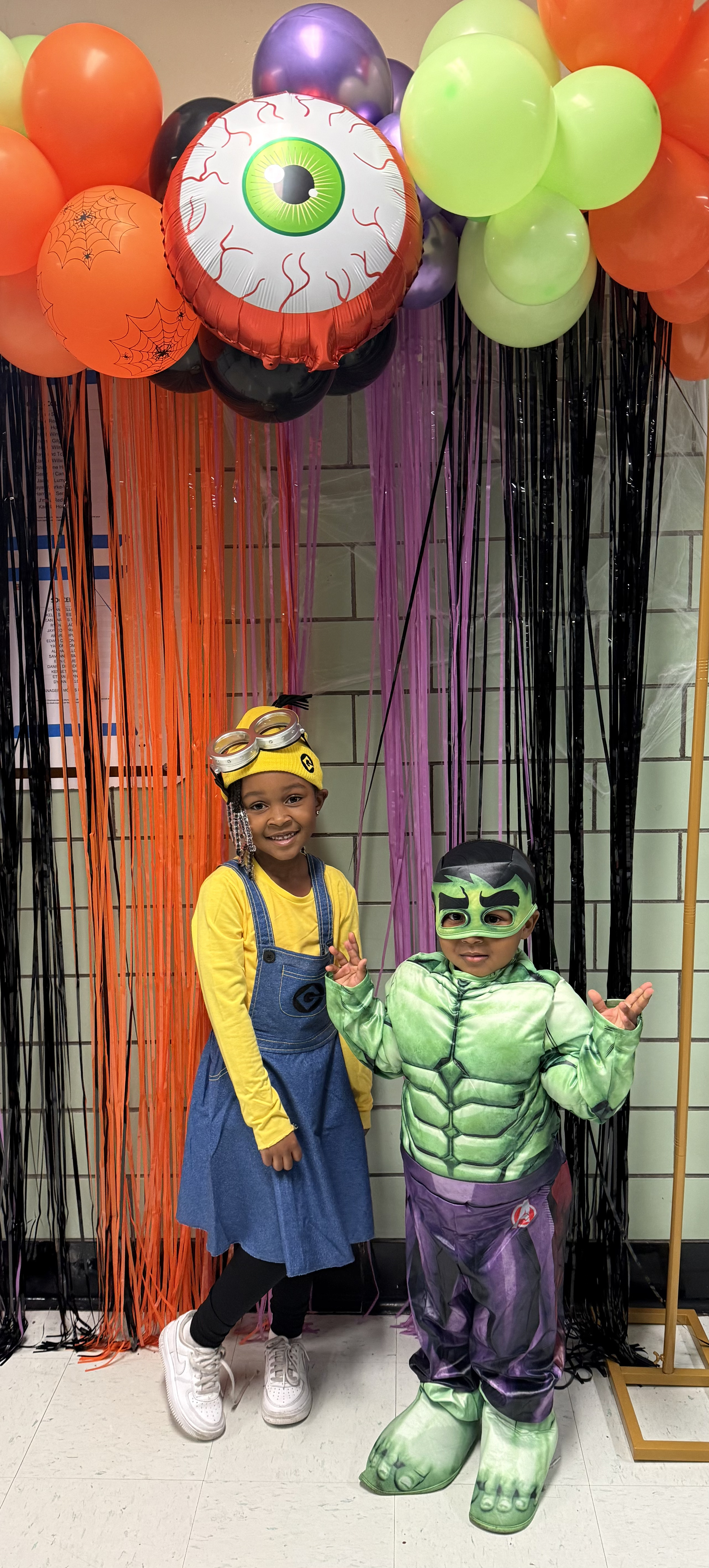 Two students in Minion and Hulk Halloween costumes at school