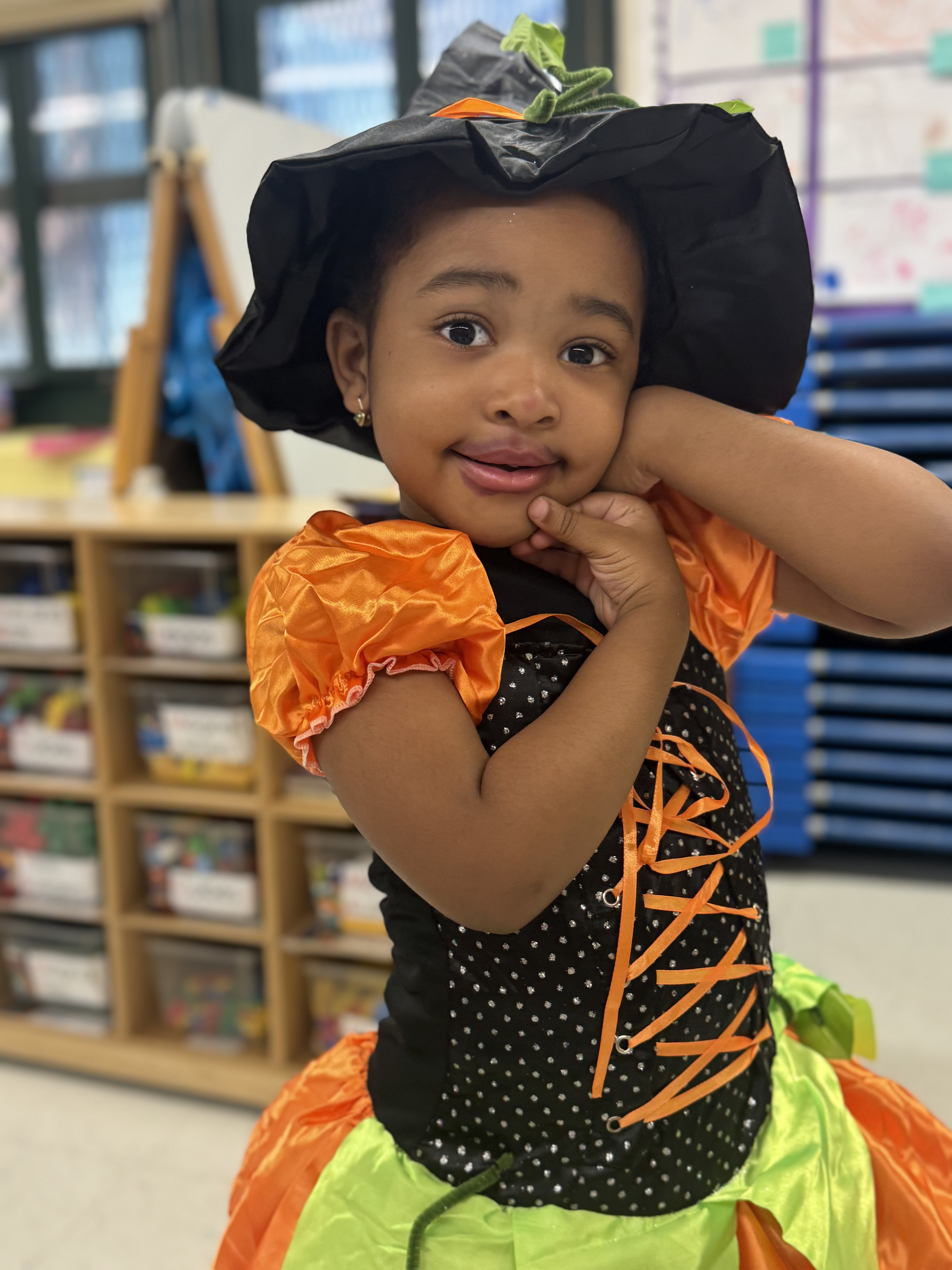 Young student wearing a Halloween witch costume in classroom