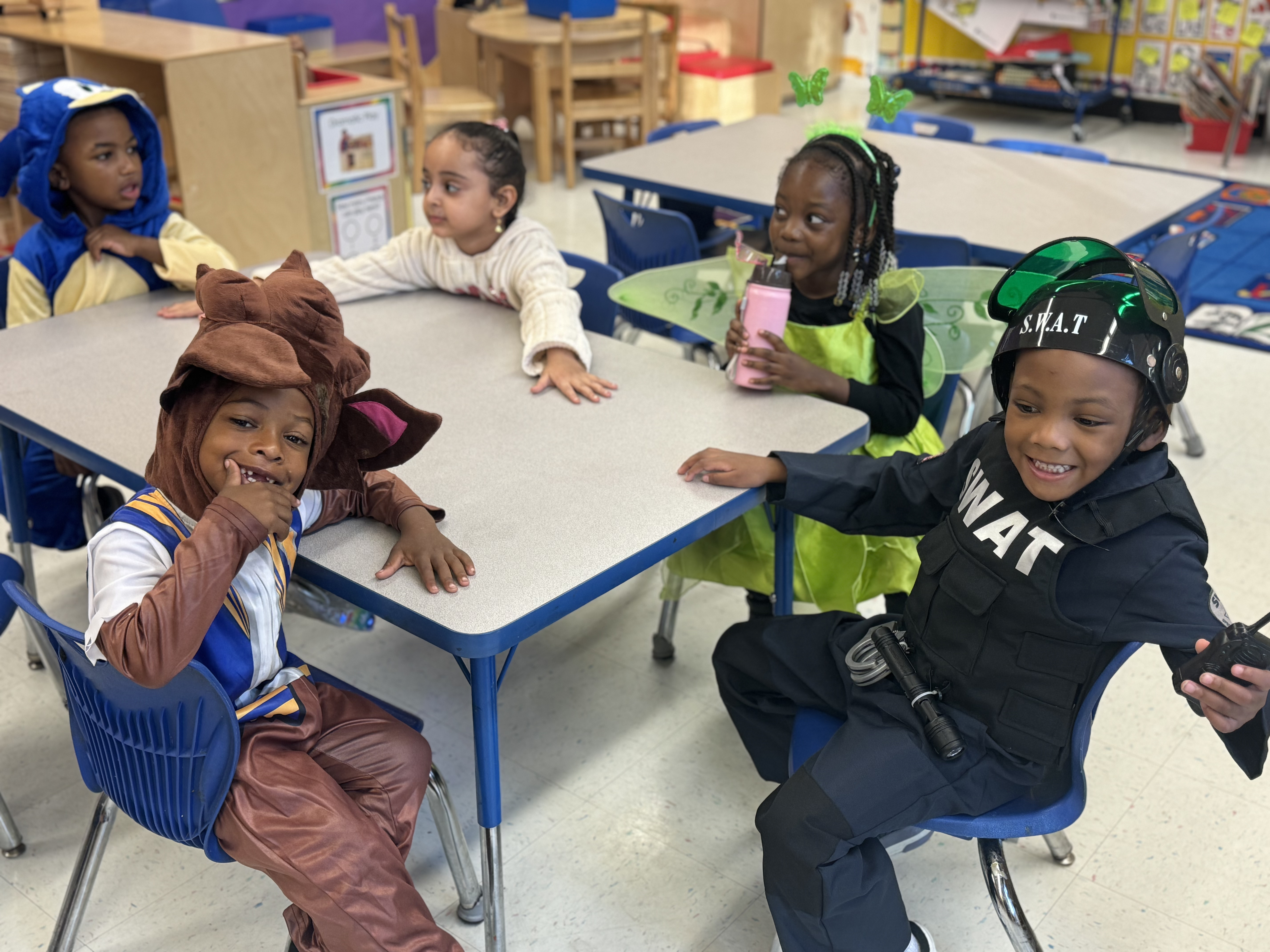 Young students in Halloween costumes celebrating in their classroom