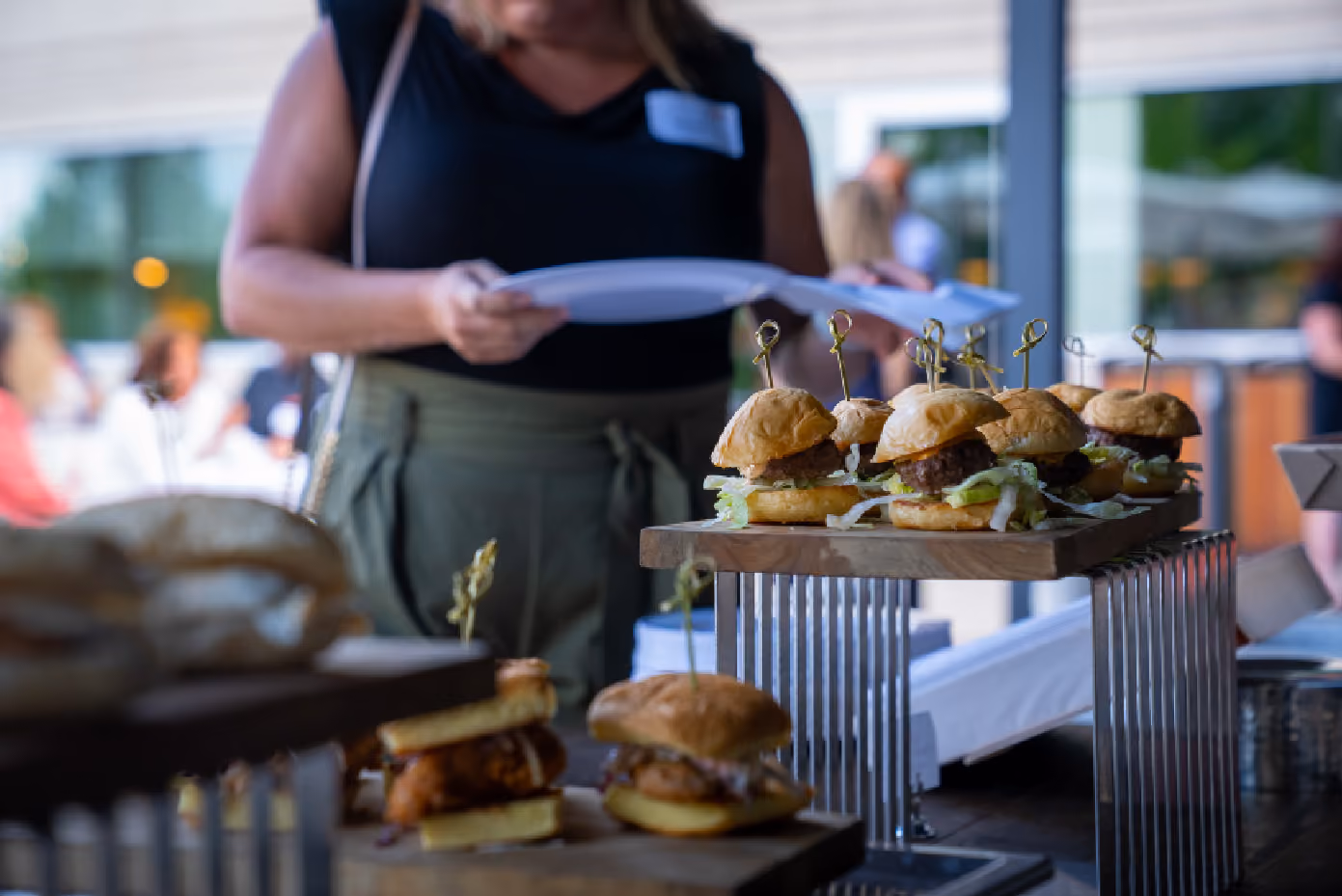 A tray of cheeseburgers at a catered event