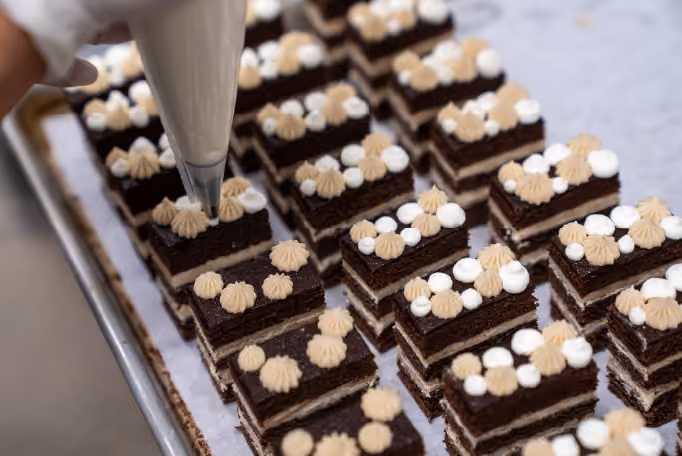 Slices of cake on a tray being decorated