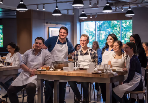 A group image of people smiling during a cooking class