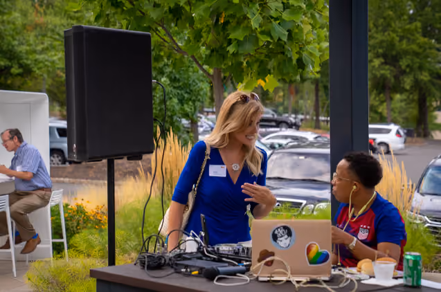 A woman talking to the DJ at an event