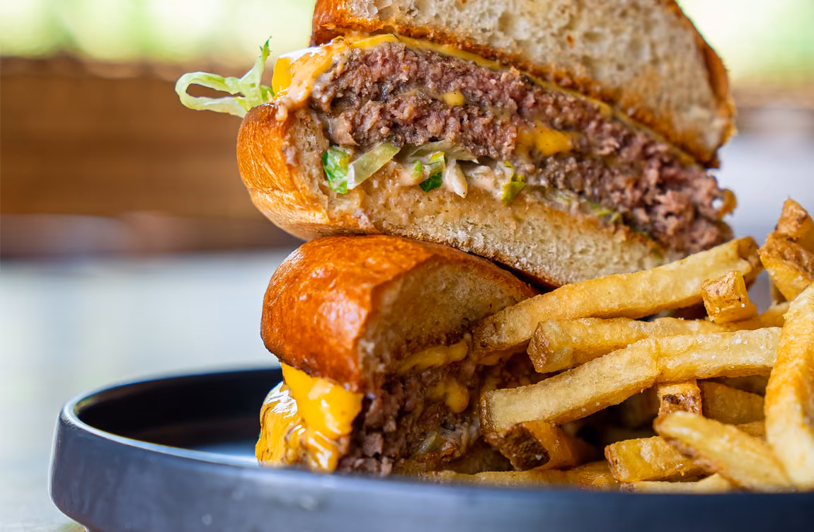 Two halves of a cheeseburger stacked on top of each other