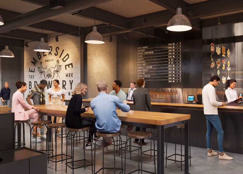 A couple sitting at a table inside of Emberside Brewery