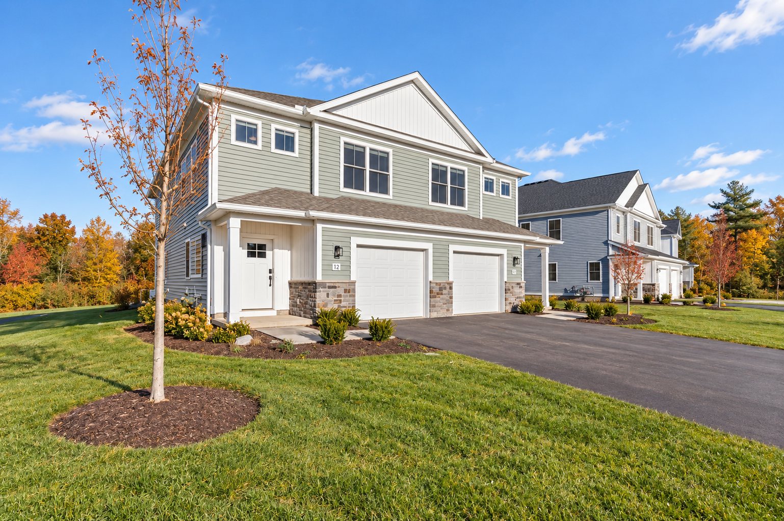 Grand Meadows duplex townhomes with attached garages in fall (digitally enhanced image)