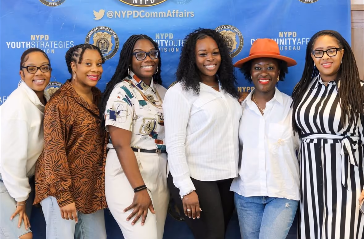 Six women posing together at NYPD Community Affairs Bureau event