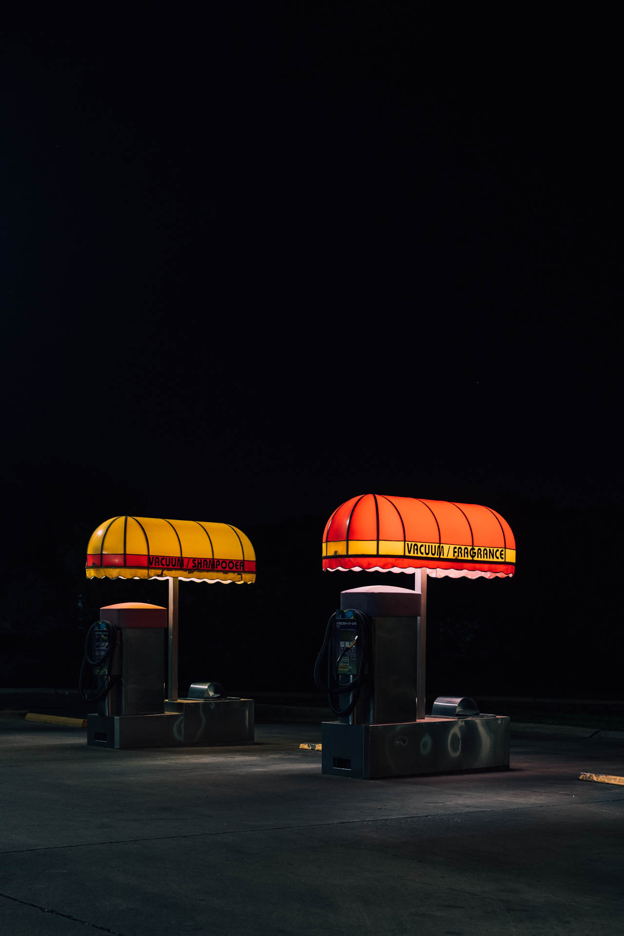 two vacuum stations at a retro car wash at night