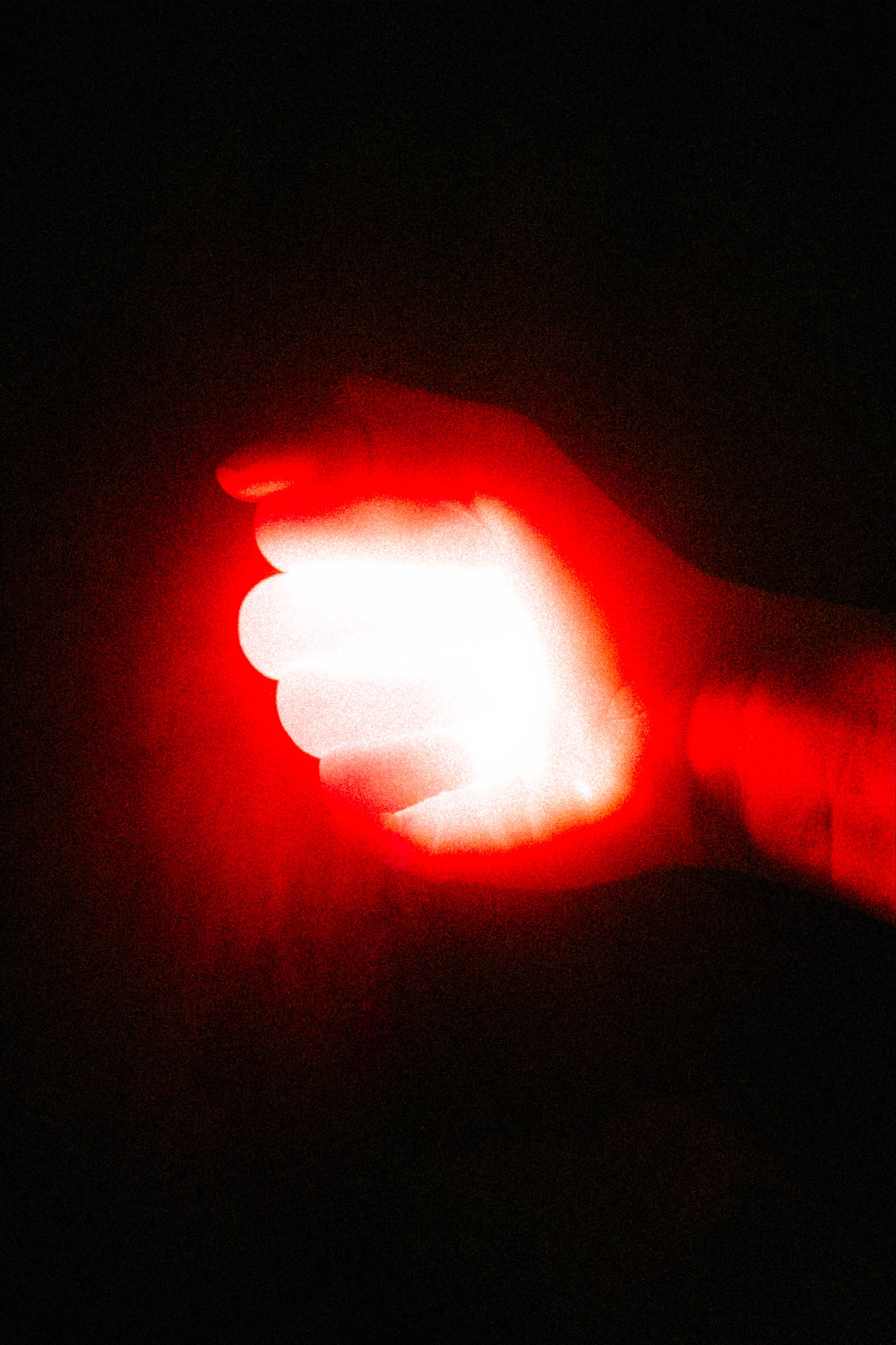 grainy red hand holding red light