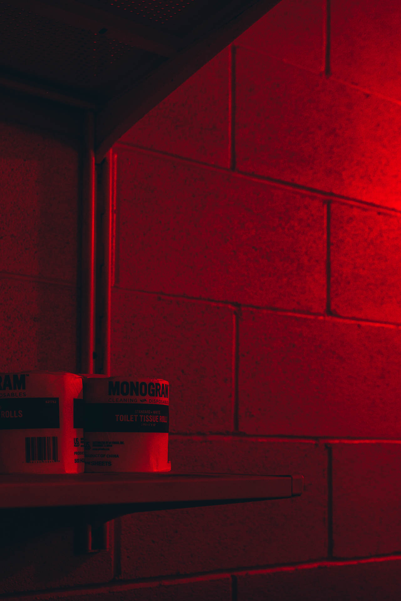 toilet paper in a red lit bathroom at night