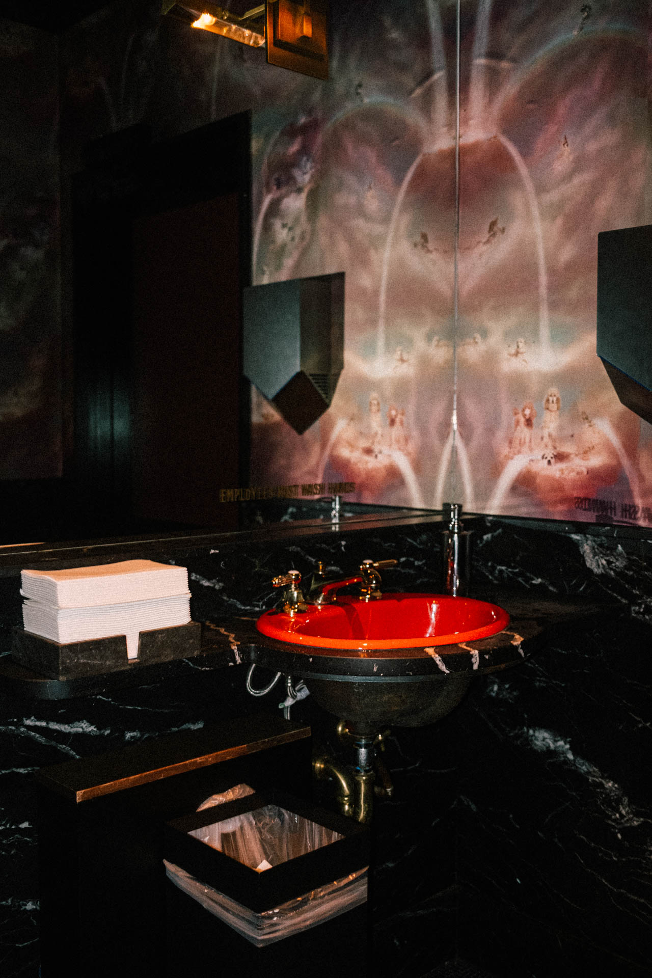 bright red sink and napkins in a holographic wallpaper bathroom
