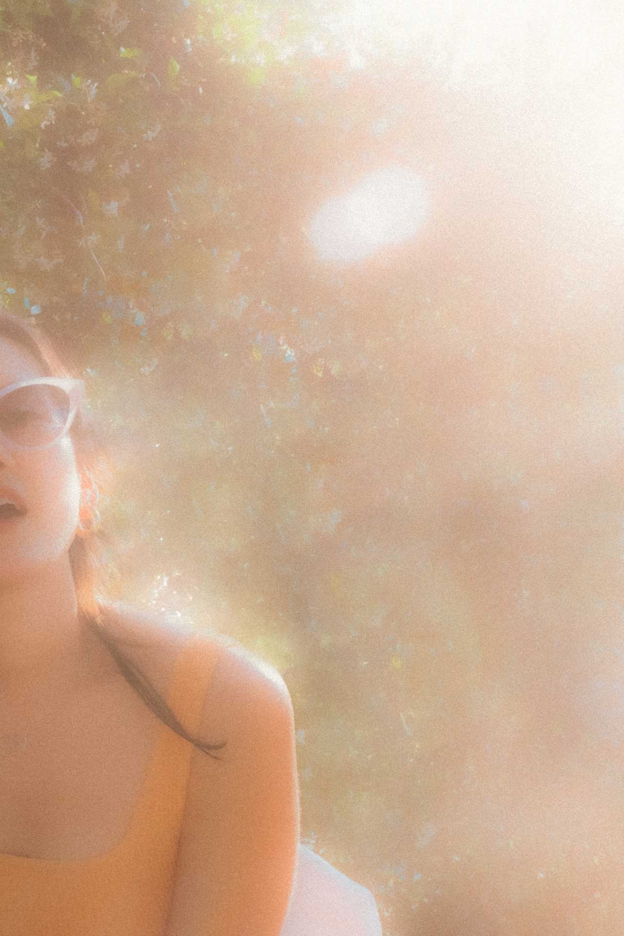 A warm grainy image of a woman in a dreamy sunset
