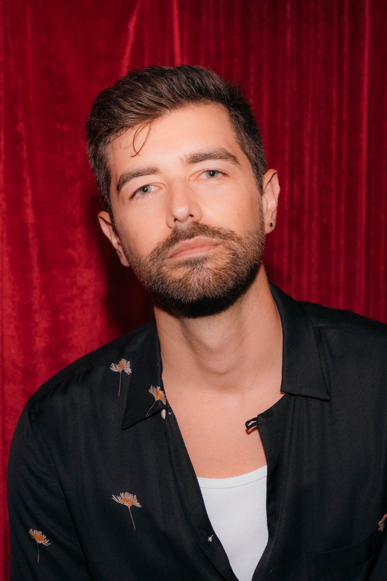 Jonathan Grado portrait in red velvet room and dandelion shirt
