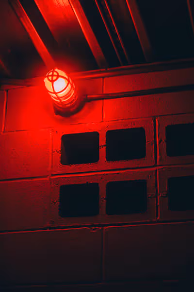 a red light lighting up breeze blocks in a bathroom at night
