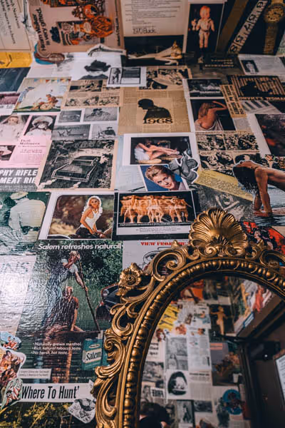 stickers and posters lining the walls of a bathroom