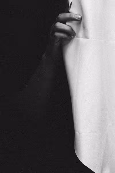 hand holding open a window curtain