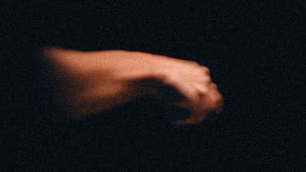a hand coming out of shadows holding something