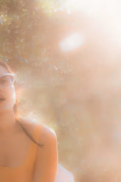 A warm grainy image of a woman in a dreamy sunset