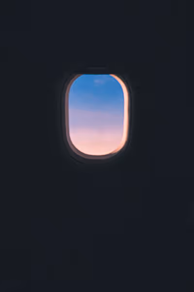 pink and purple sunrise through a plane window