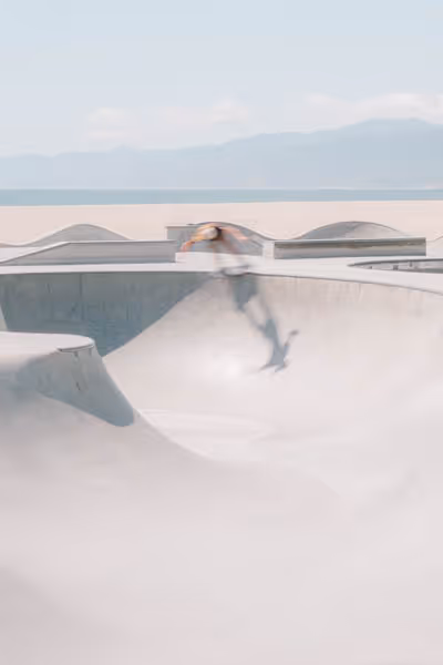 Venice Beach skateboarder in the distance in motion on a sunny day by the beach