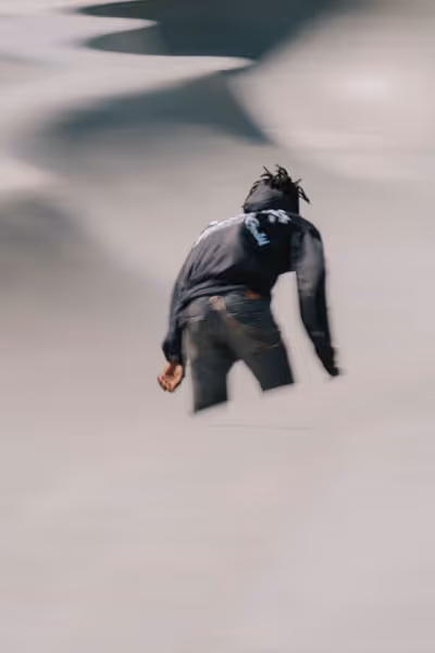 Venice Beach skateboarder in a black hoodie in motion on a sunny day by the beach