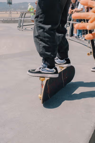 Skateboarder standing on the trucks of their skateboard