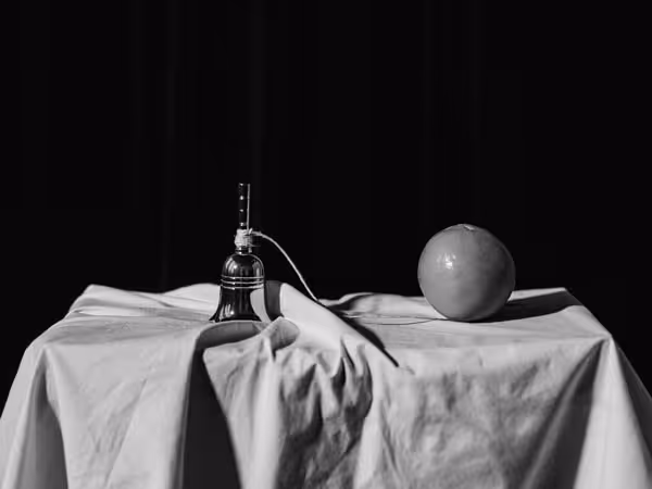 Hand bell and orange together connected by a string