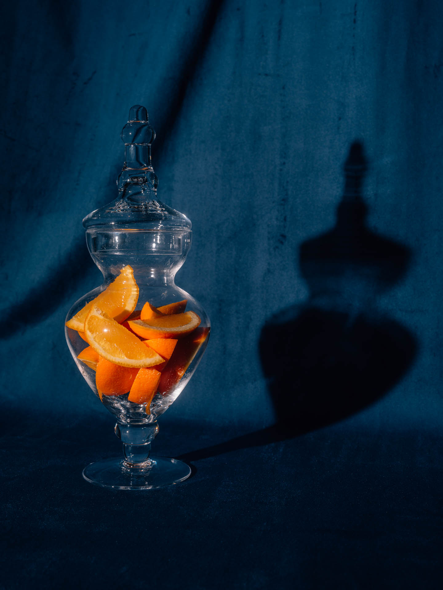 Orange slices in a candy jar on blue velvet