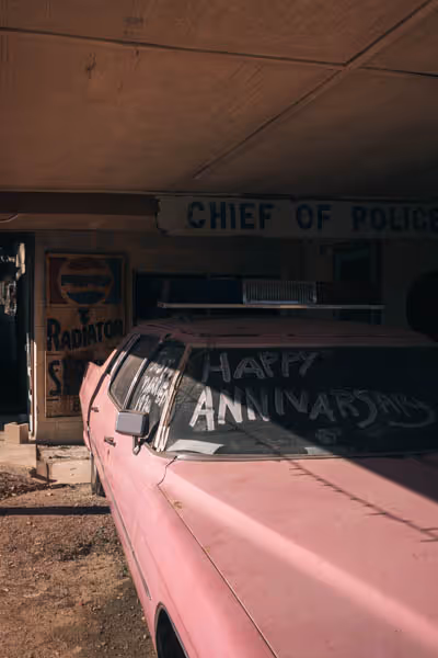 old pink car with happy anniversary written on the windshield
