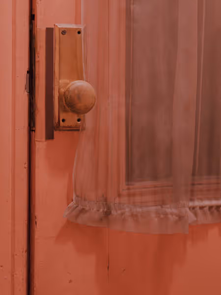 pink door and knob on a dreamy and grainy old door with a window curtain