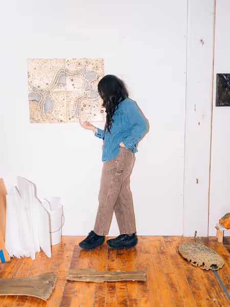 Lara Saget standing with her sculptures in her studio
