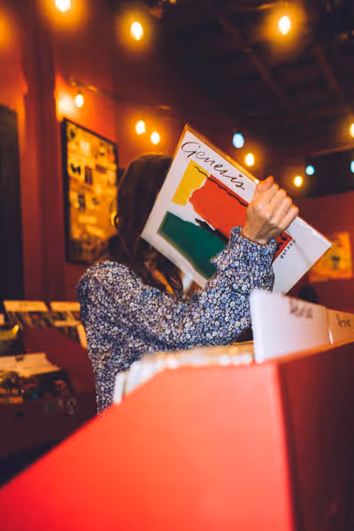 woman holding a vinyl record at night in Austin