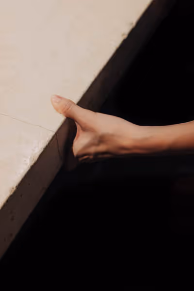 a woman's hand holding onto a cement bar counter
