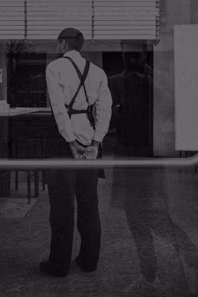 Jonathan Grado in reflection and waiter working. Walking in New York. Grainy