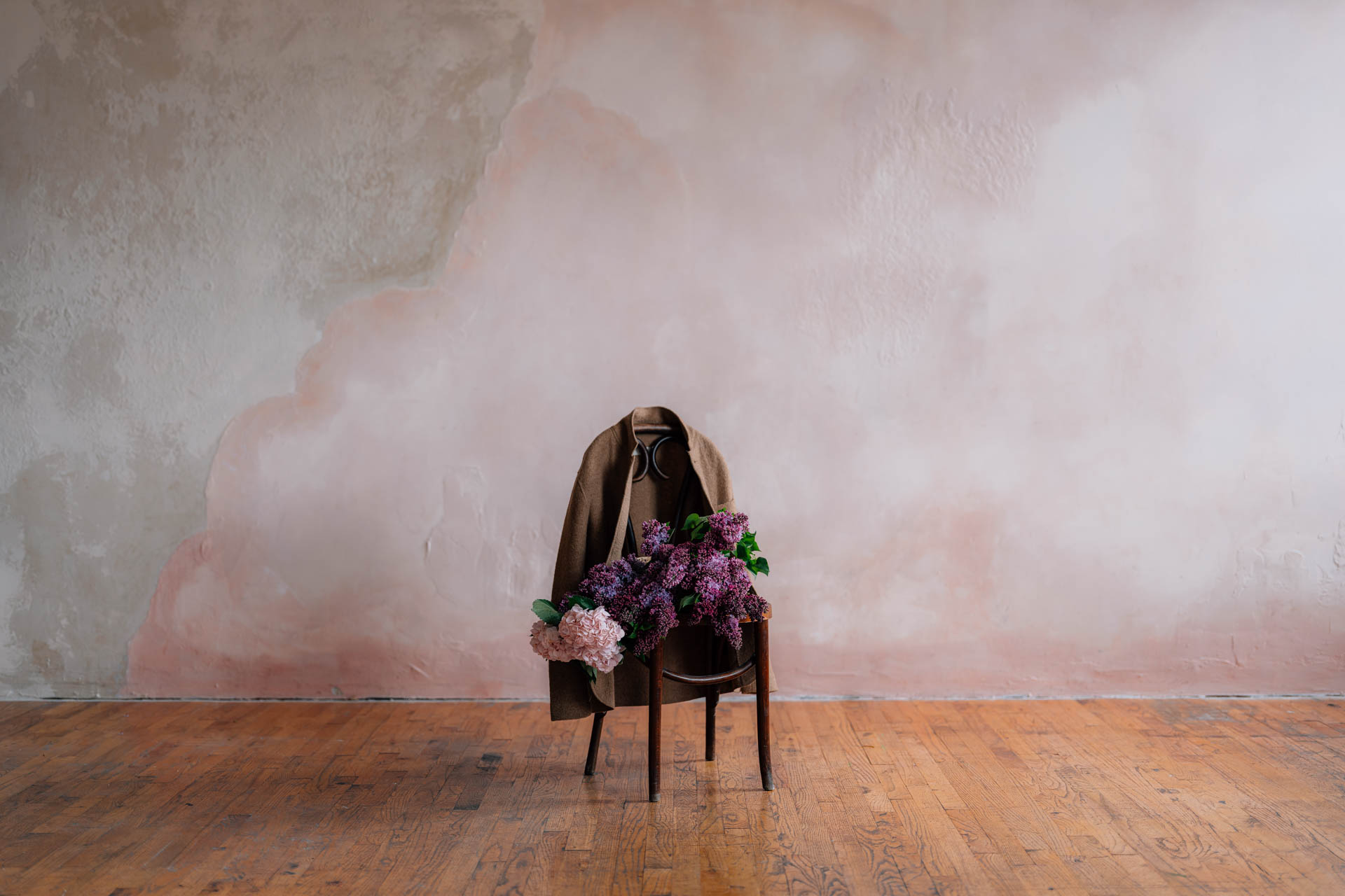 lilacs and hydrangeas flower bouquet on chair with felted jacket